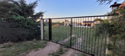 a gate in a yard with a playground behind it at El Coronillo - Lodge in Concepción del Uruguay