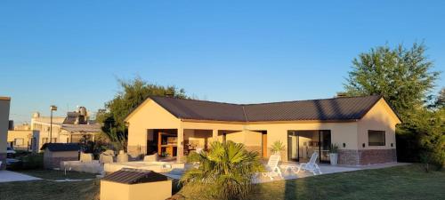 une maison avec un toit et une cour dans l'établissement El Coronillo - Lodge, à Concepción del Uruguay
