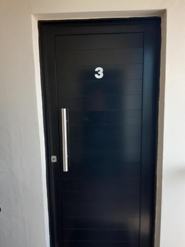 a black door with the number three on it at Ayres Del Rio Uruguay in Colón