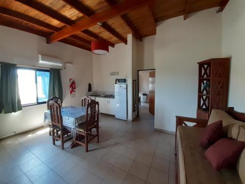 a kitchen and living room with a table and chairs at Ayres Del Rio Uruguay in Colón