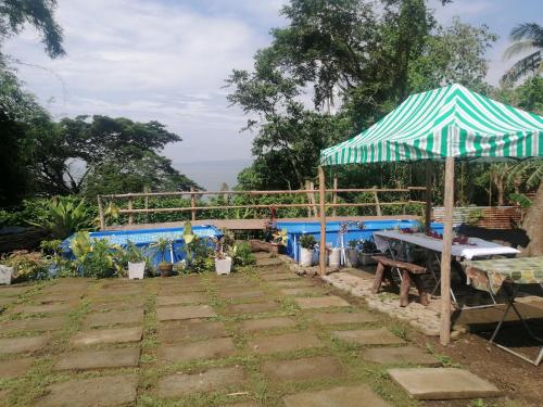 - une terrasse avec un parasol et une table dans l'établissement Hilltop Canopy Staycation, à Kinalaglagan
