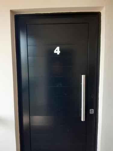 a black door with the number four on it at Ayres Del Rio Uruguay in Colón