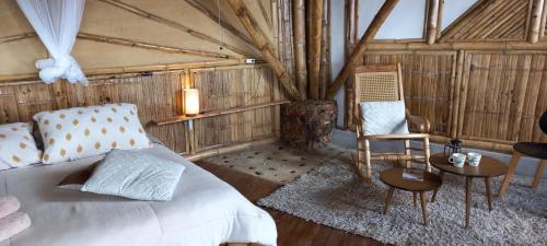 a bedroom with a bed and a chair and a table at Ecohotel Soplo del Tambo in Cocorná