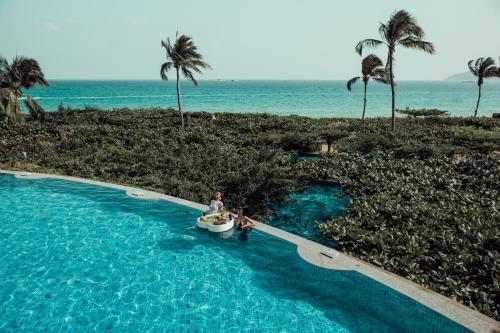 三亞的住宿－三亚亚龙湾天域度假酒店（接机+林荫泳池），海滩旁的游泳池里的一个男人