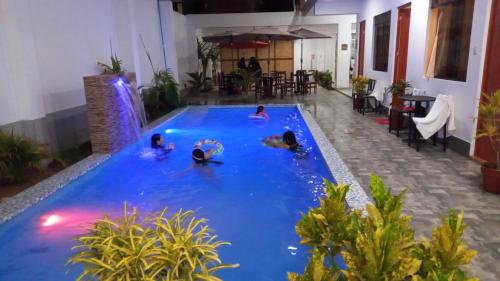 a group of people swimming in a swimming pool at Hospedaje Ola Marina in Máncora