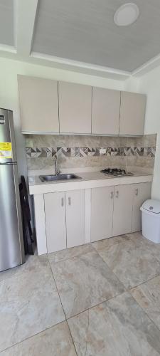 uma cozinha com armários brancos e um lavatório em Apartamento Turistico Soul em La Loma