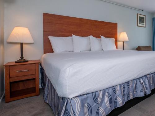a large bed in a hotel room with two lamps at Sea Latch Inn in York Beach
