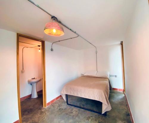 a bedroom with a bed and a lamp at Ticuchi Hostal in Oaxaca City