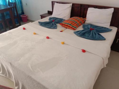a white bed with four pillows and blankets on it at Serenity Lake Resort Yala in Tissamaharama