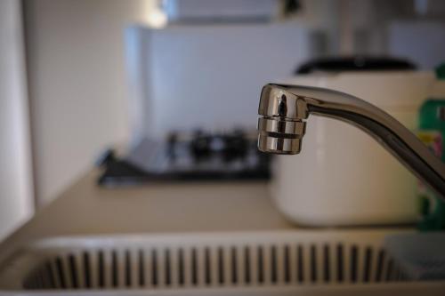 a kitchen sink with a faucet on a counter at Blue Entrance in Onna