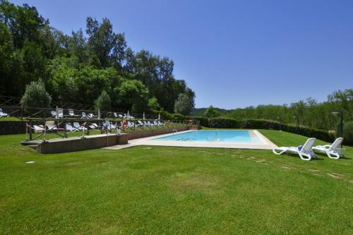 een zwembad in een grasveld met ligstoelen bij Francigena Apartments Castelfiorentino - Happy Rentals in Castelfiorentino