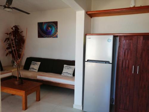 uma sala de estar com um frigorífico e um sofá em Casa La Quinta Ola em Troncones