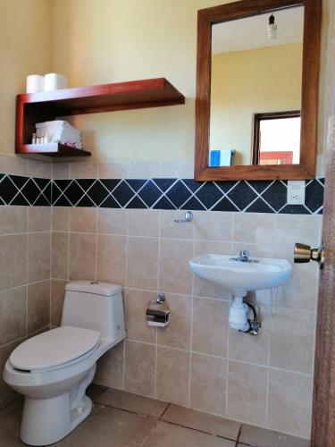 a bathroom with a toilet and a sink at Casa La Quinta Ola in Troncones