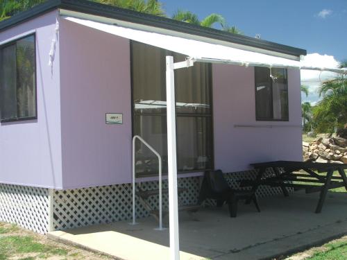 a purple house with a picnic table on a patio at Horseshoe Bay Resort in Bowen
