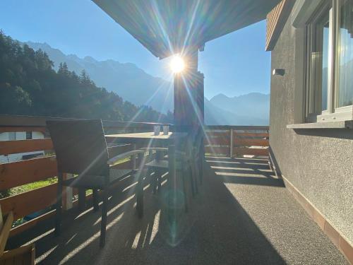 a table and chairs on a balcony with the sun shining at Appartement Schillerkopf in Bludenz