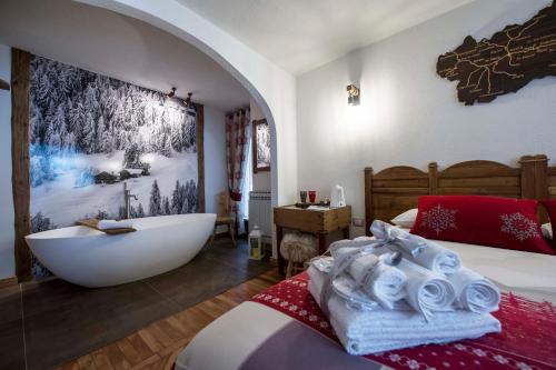 a bedroom with a bath tub and a bed with towels at Le Relais du Boucher in Gaby