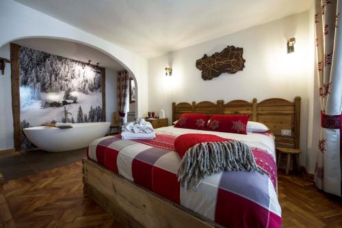 a bedroom with a large bed and a bath tub at Le Relais du Boucher in Gaby