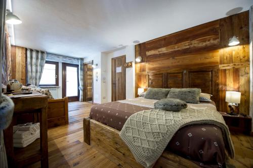 a bedroom with a bed and a wooden wall at Le Relais du Boucher in Gaby