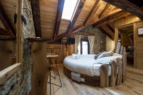 a bedroom with a bed in a log cabin at Le Relais du Boucher in Gaby