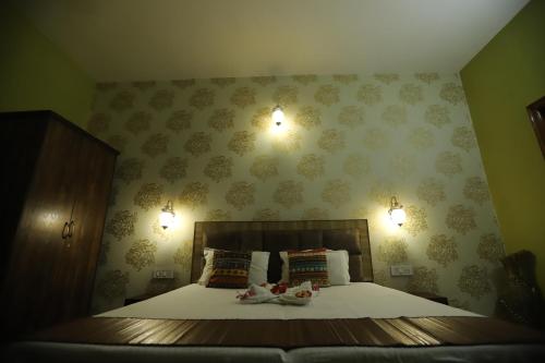 a bedroom with a bed with two dolls on it at Karta-Purakh an Ayurvedic Stay in Amritsar