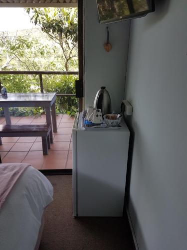 a room with a white refrigerator next to a balcony at Candleberry Stay in East London