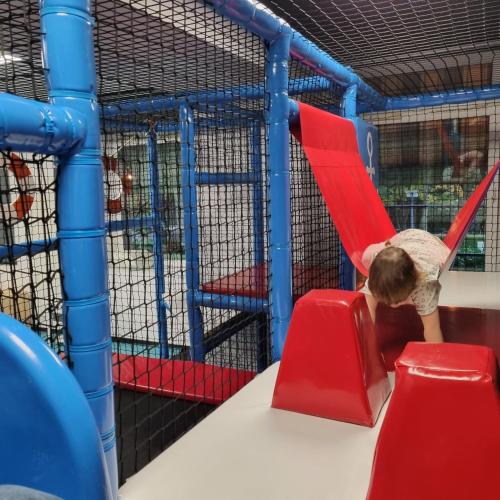 a child playing in a red slide at a playground at AQUA HOUSE in Sopot
