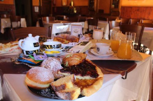 サンタンジェロ・イン・ヴァードにあるBed and Breakfast Dal Tenenteのペストリー、コーヒー、オレンジジュースを用意したテーブル