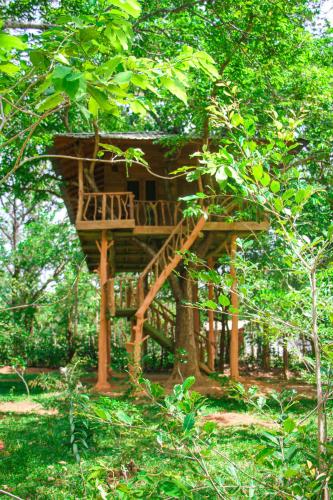 a tree house in the middle of a forest at Lotus Eco Villa in Sigiriya
