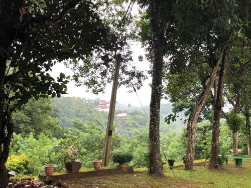 a park with trees and a sign in the distance at Captain's Bungalow, Kandy in Arawwawala