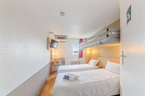 a hotel room with two beds and a tv at Kyriad Direct Annemasse - Genève in Gaillard