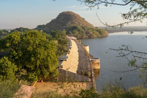 a bridge over a river with a mountain in the background at RAAS Chhatrasagar, Nimaj, District Pali in Pāli