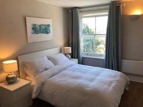 a bedroom with a white bed and a window at Flagstaff Court in Kent