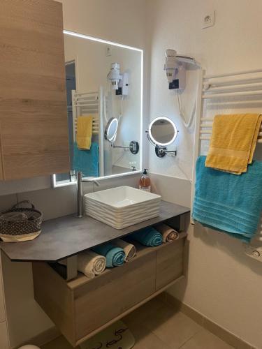 ein Badezimmer mit Waschbecken, Spiegel und Handtüchern in der Unterkunft Villa Fior 50 in Santa-Maria-Poggio