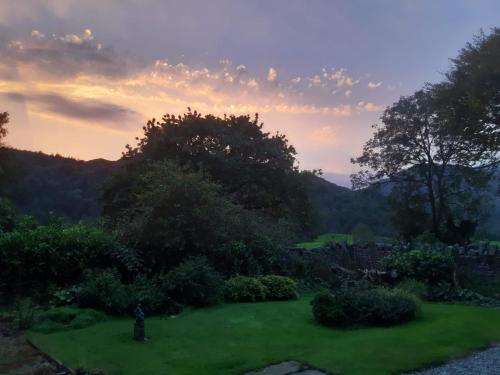 a view of a garden at sunset at Crow How Country Guest House in Ambleside