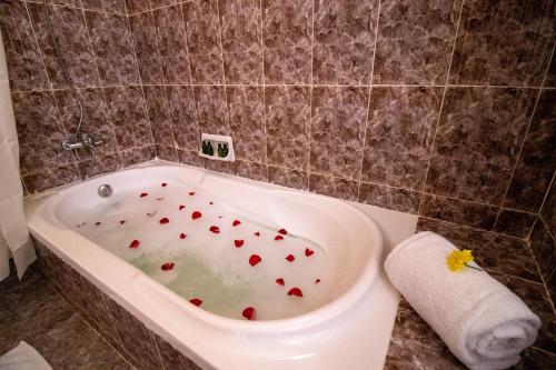 a bathroom with a bath tub with red hearts in it at Sunny Palms Beach Bungalows in Uroa