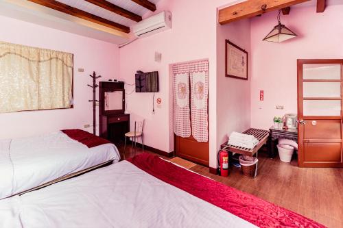 a bedroom with two beds and a desk at Cui Song Yuan Homestay in Tongxiao