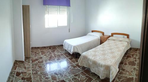 1 dormitorio con 2 camas y ventana en Lucena-Piso amplio y luminoso, en Lucena