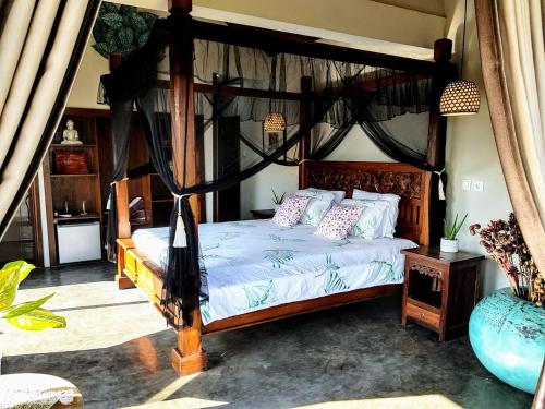 a bedroom with a canopy bed in a room at Ombak Resort at Ekas , a luxury surf and kite destination, Close to Inside Ekas beach in Ekas