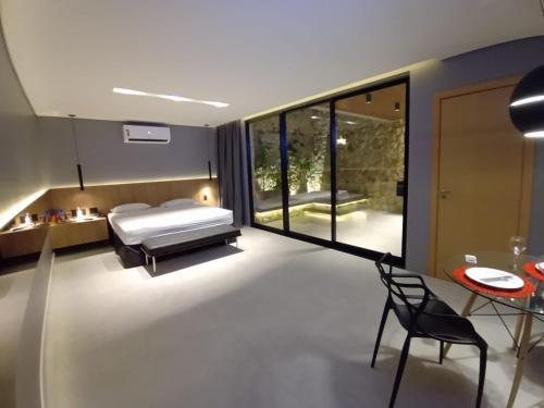 a bedroom with a bed and a table and a chair at Motel UP (Adult Only) in Fortaleza