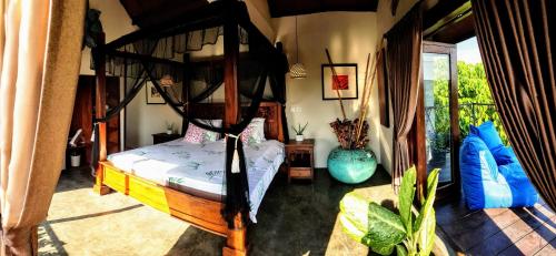 a bedroom with a canopy bed in a room at Ombak Resort at Ekas , a luxury surf and kite destination, Close to Inside Ekas beach in Ekas