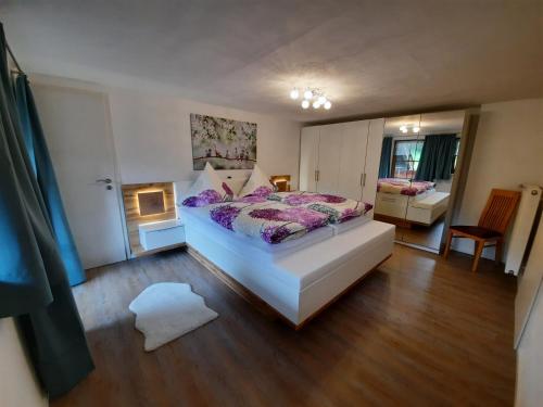 1 dormitorio con 1 cama blanca grande con sábanas moradas en Ferienwohnung Kiliansblick in der Kilianmühle, en Berchtesgaden