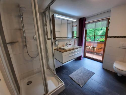 a bathroom with a shower and a sink and a toilet at Ferienwohnung Kiliansblick in der Kilianmühle in Berchtesgaden