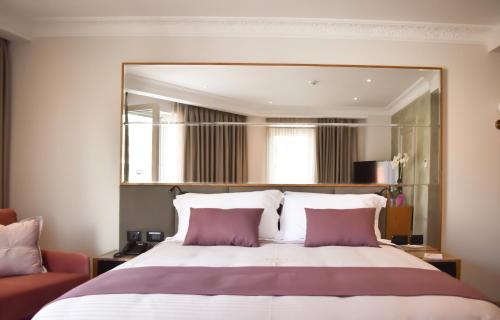 a bedroom with a large bed with a large mirror at Giulia Albérgo Hotel in Durrës