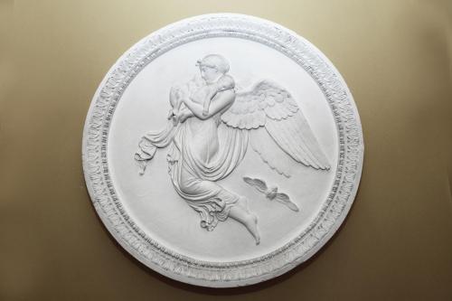 a white plate with an angel on a wall at Hotel Gunia in Berlin