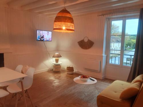 a living room with a couch and a table at Maison avec jardin dans petit bourg typiquement Percheron - Le Colombier in Boissy-Maugis
