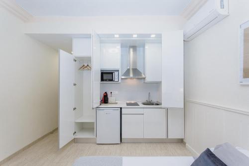 a white kitchen with a sink and a microwave at Apartamento San Pascual 18 III en Orihuela in Orihuela