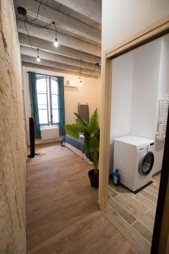 - un salon avec un lave-linge et un canapé dans l'établissement Remparts - Duplex climatisé, à Arles