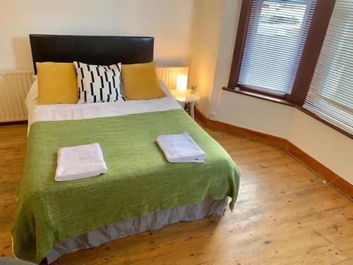 a bedroom with a large bed with two towels on it at Balham, South London Spacious Guest House 1 in London