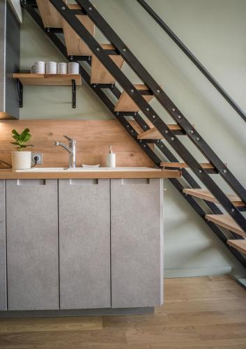 - une cuisine sous les escaliers avec un évier dans l'établissement Magnifique Duplex Oneigedor Départ ski aux pieds et vue montagne, à Tignes