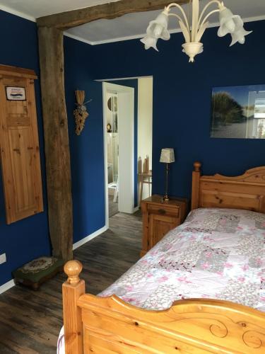 a bedroom with a wooden bed and blue walls at The Cozy Cottage in Rieden